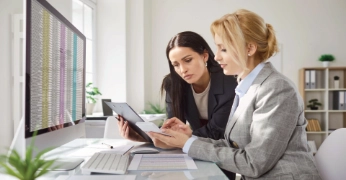 Finance professionals reviewing data on an office computer